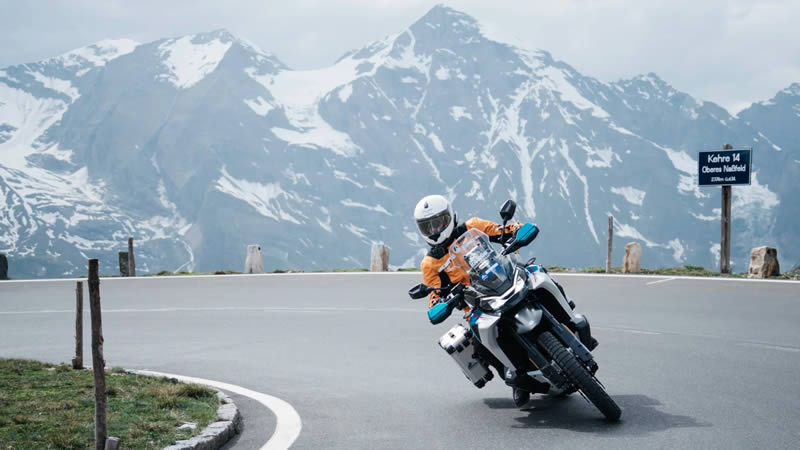 Motocykl CFMOTO 800MT-X Motocykl CFMOTO 800MT-X projíždějící zatáčku v serpentinách v Alpách